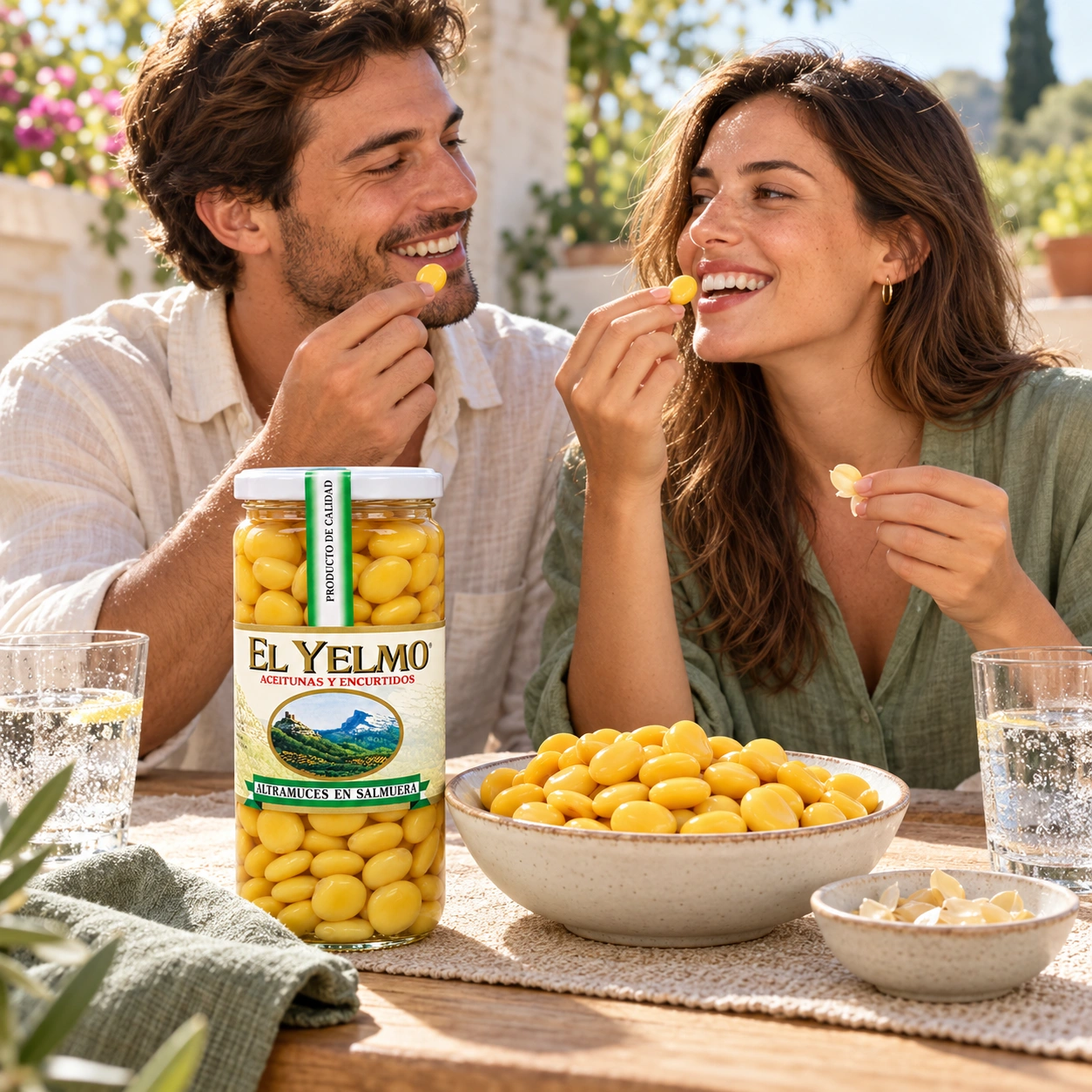 Pareja joven comiendo altramuces en una terraza, con un cuenco y un tarro El Yelmo sobre la mesa.