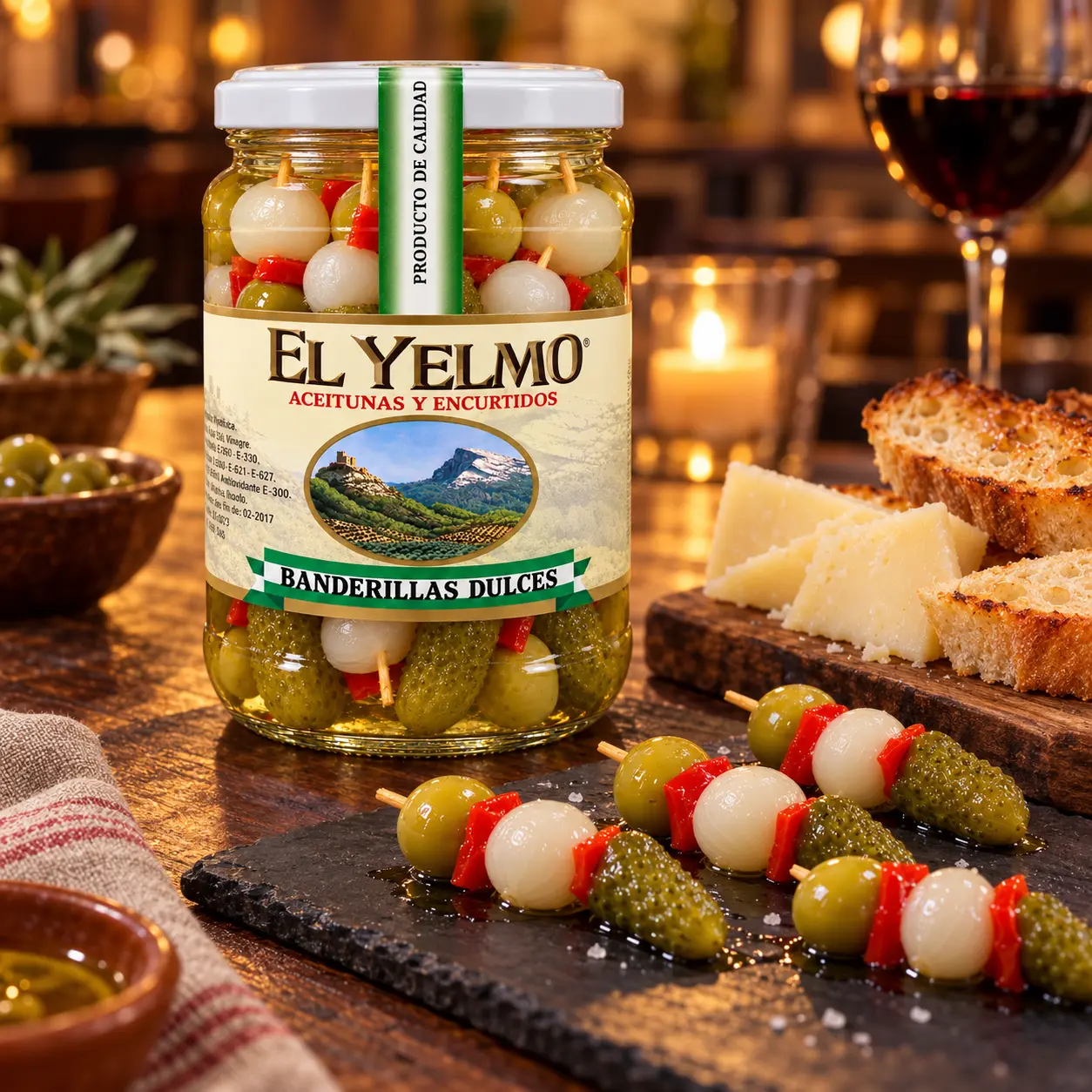 Tarro de banderillas dulces El Yelmo de 325 g con brochetas, queso y tostadas en una mesa de tapas